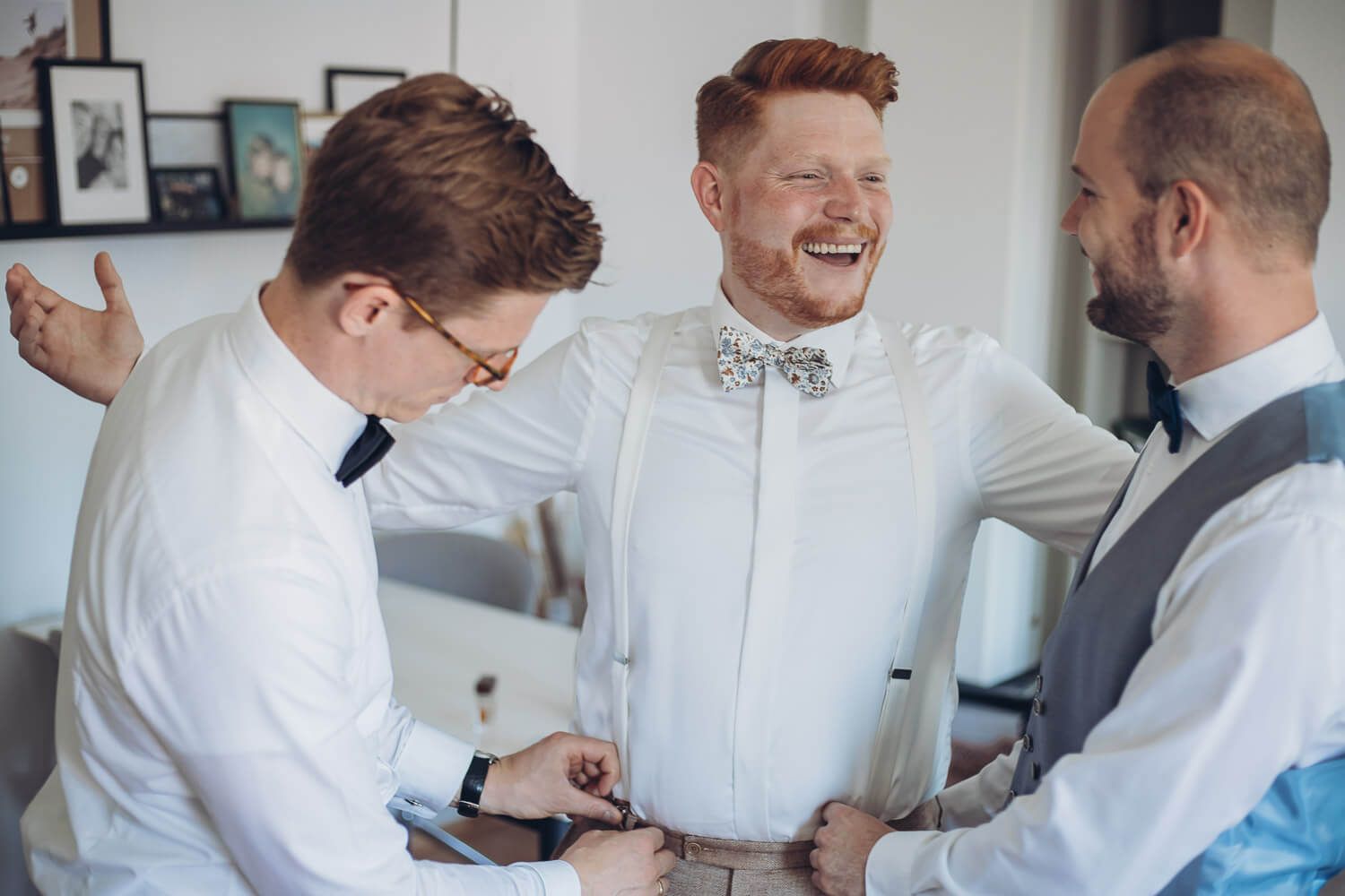 Der Bräutigam lacht gemeinsam mit seinen Freunden während des Getting Ready ein Moment aus der fotografischen Begleitung einer freie Trauung