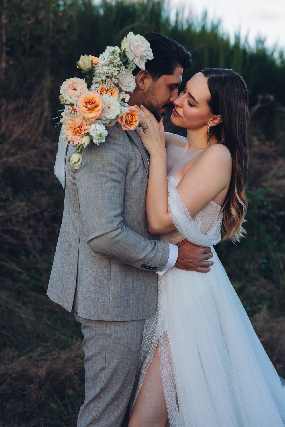Braut und Bräutigam stehen eng umschlungen in der Natur bei einem romantischen Hochzeitsshooting in Hannover