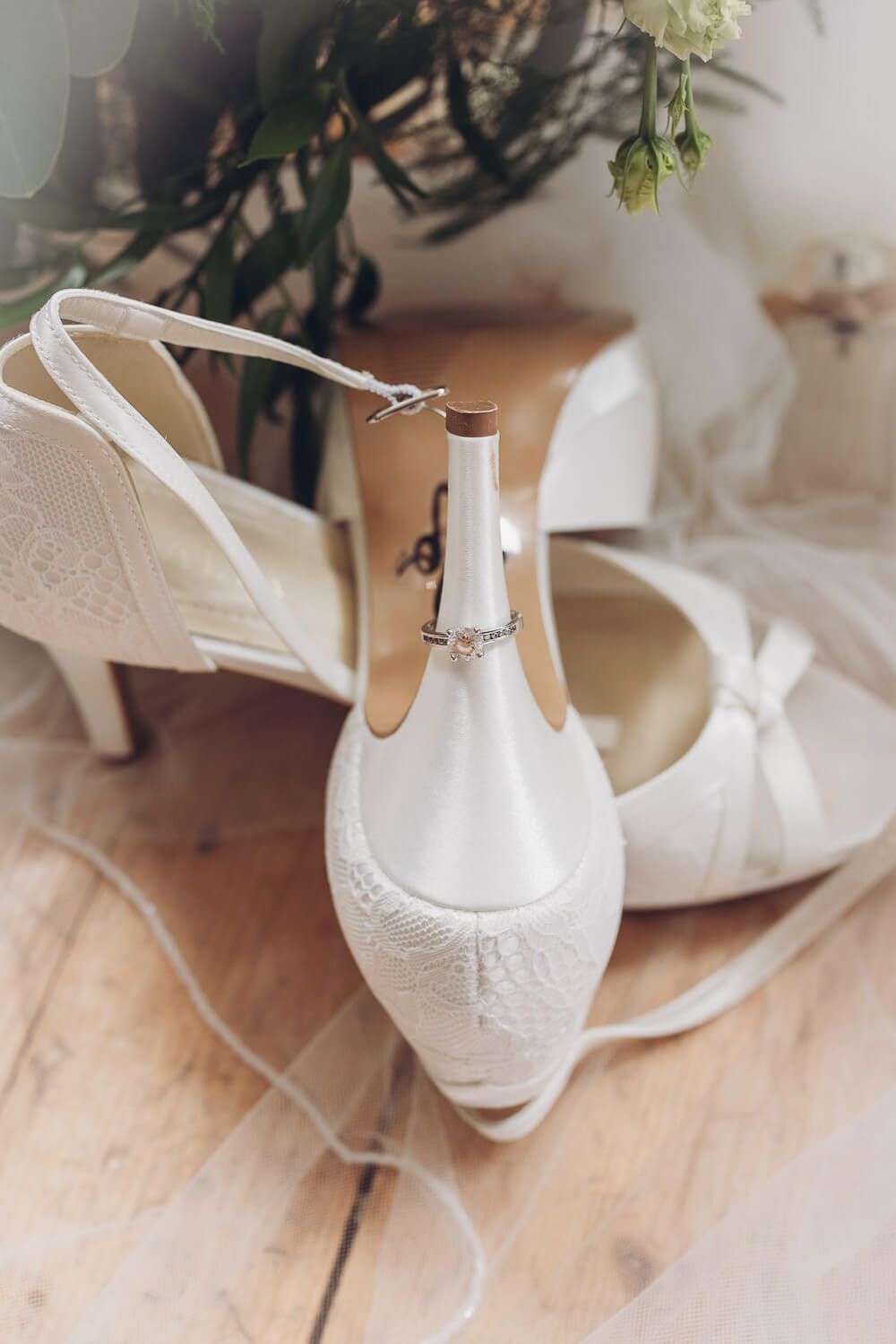 Weiße Brautschuhe mit Verlobungsring als liebevoll arrangiertes Detailfoto zur Hochzeit - Hochzeitsfotograf Hannover
