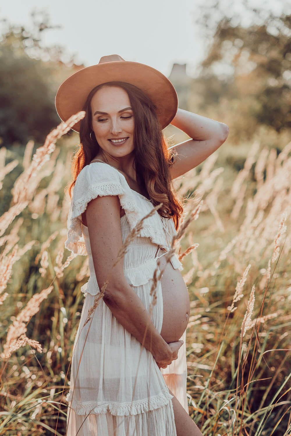 Natürliches Babybauch Shooting in Peine – schwangere Frau im Boho Kleid bei Sonnenuntergang auf einer Wiese
