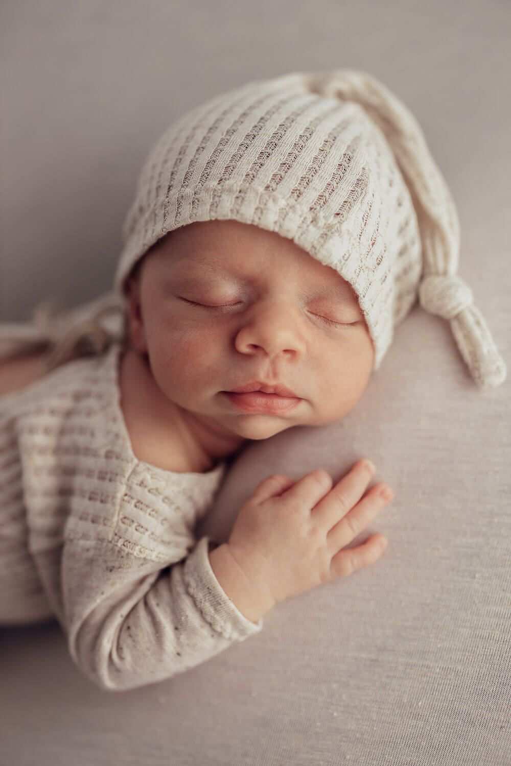 Schlafendes Neugeborenes mit Mütze bei einem ruhigen und natürlichen Newborn Fotoshooting