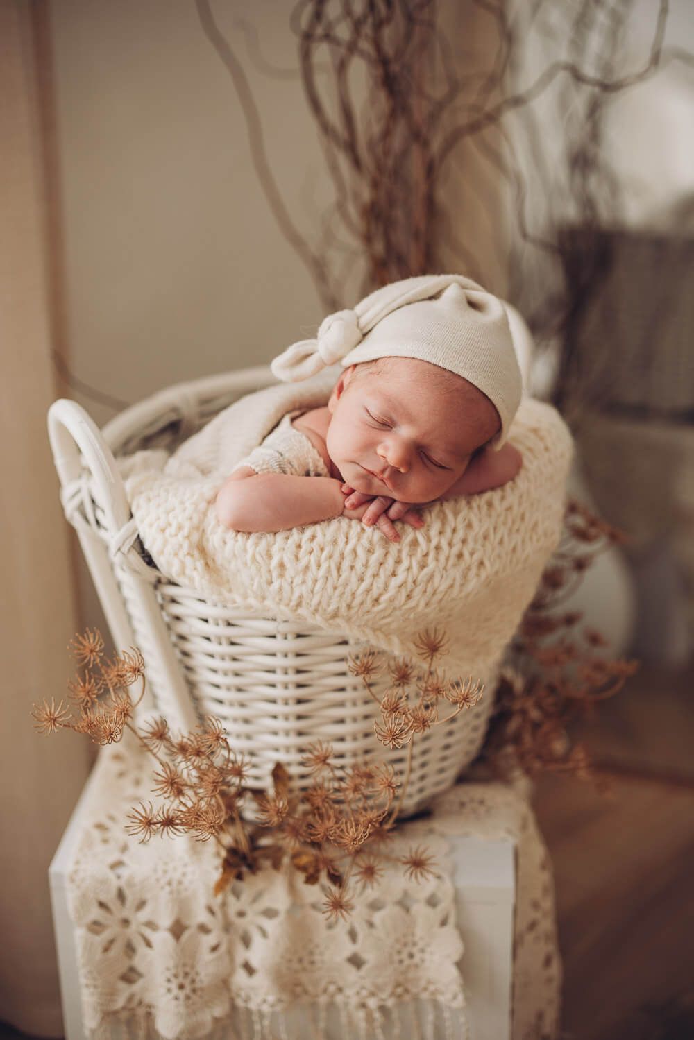 Schlafendes Neugeborenes in einem weißen Korb im natürlichen Boho-Stil bei einem Baby Fotoshooting in Minden