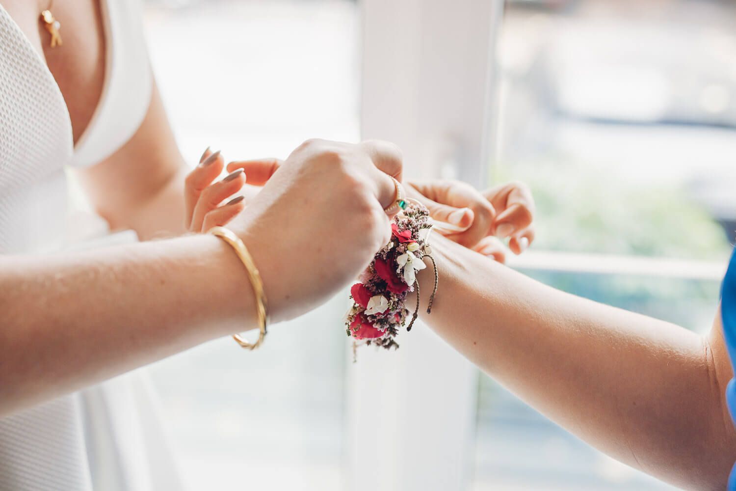 Braut bekommt ein florales Armband angelegt beim Getting Ready einer Hochzeit in Hameln begleitet vom Fotografen