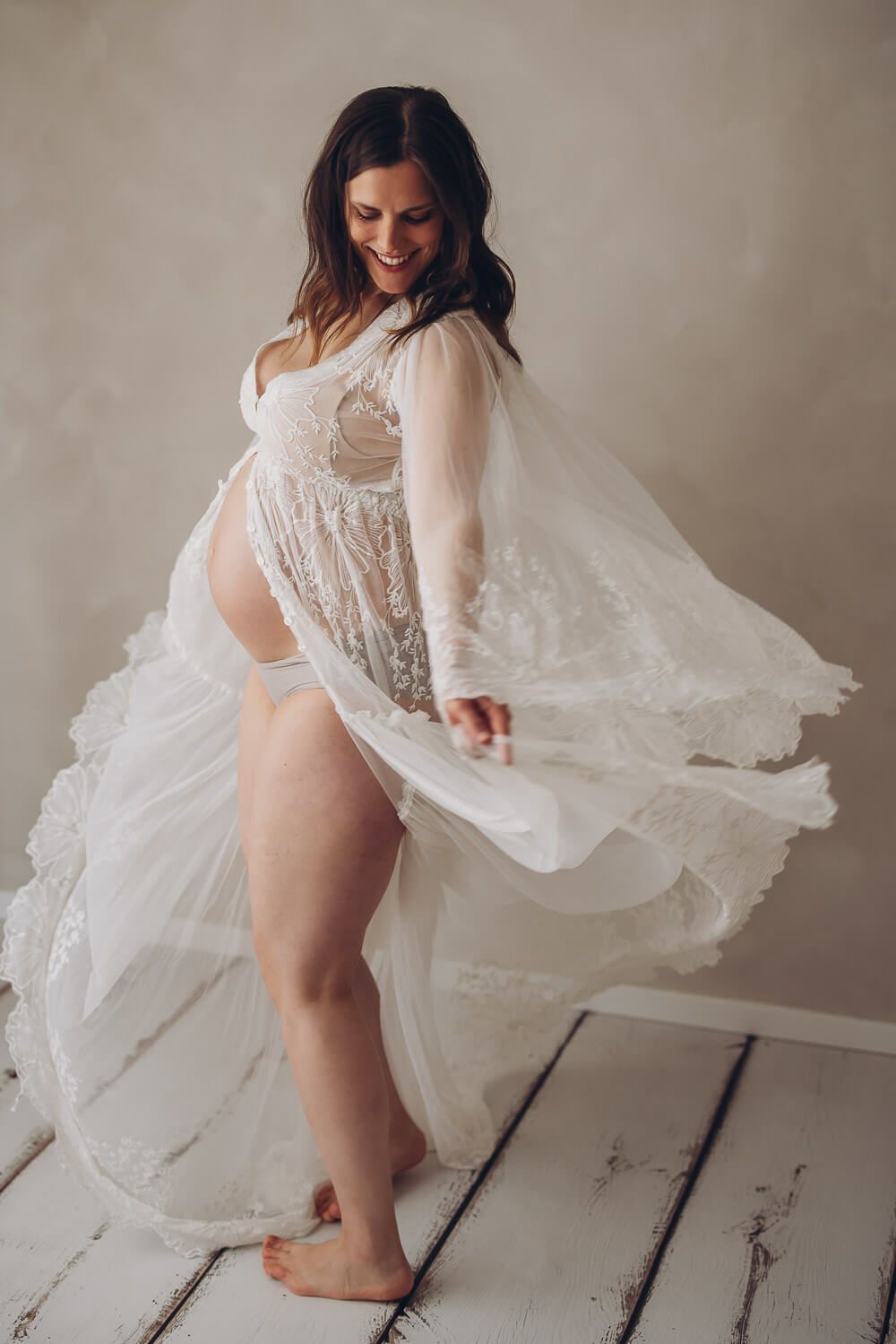 Modernes Babybauch Fotoshooting im Fotostudio in Gehrden – schwangere Frau bewegt ein fließendes Spitzenkleid