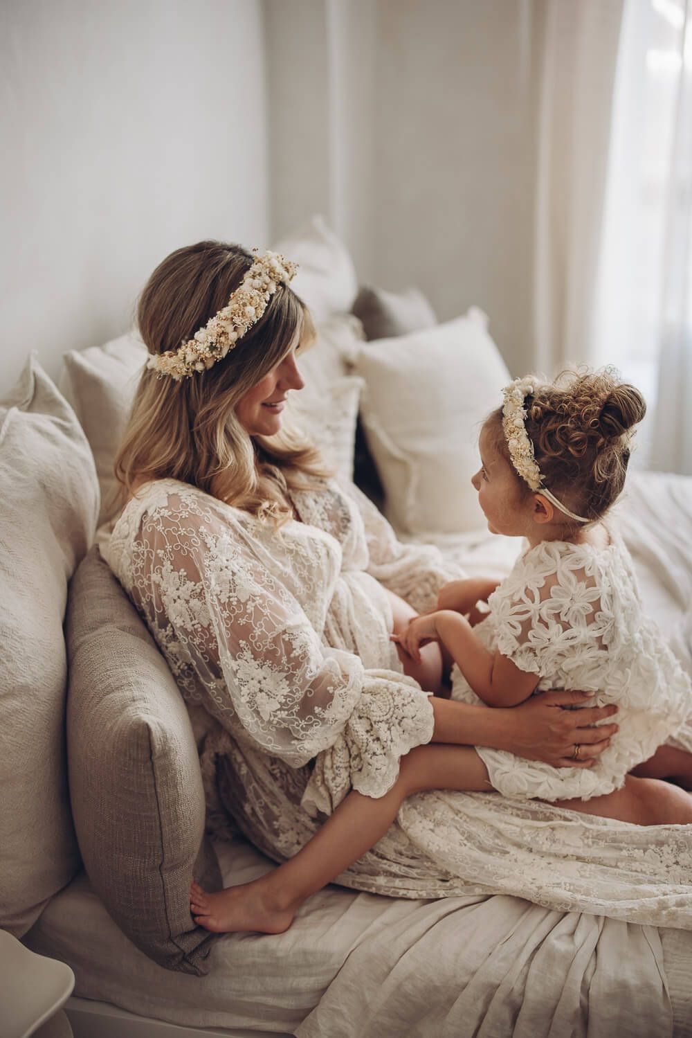 Babybauch Fotoshooting im Fotostudio in Hannover – Schwangere Frau sitzt mit Kind auf dem Bett