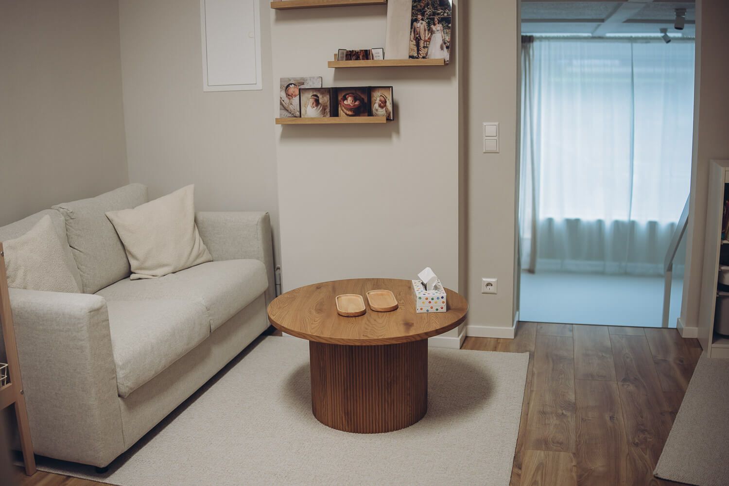 Stilvoller Wartebereich mit Sofa und Bilderregalen im Fotostudio Hannover, einladendes Atelier für Fotografie, Familienfotos, Babybauchfotos