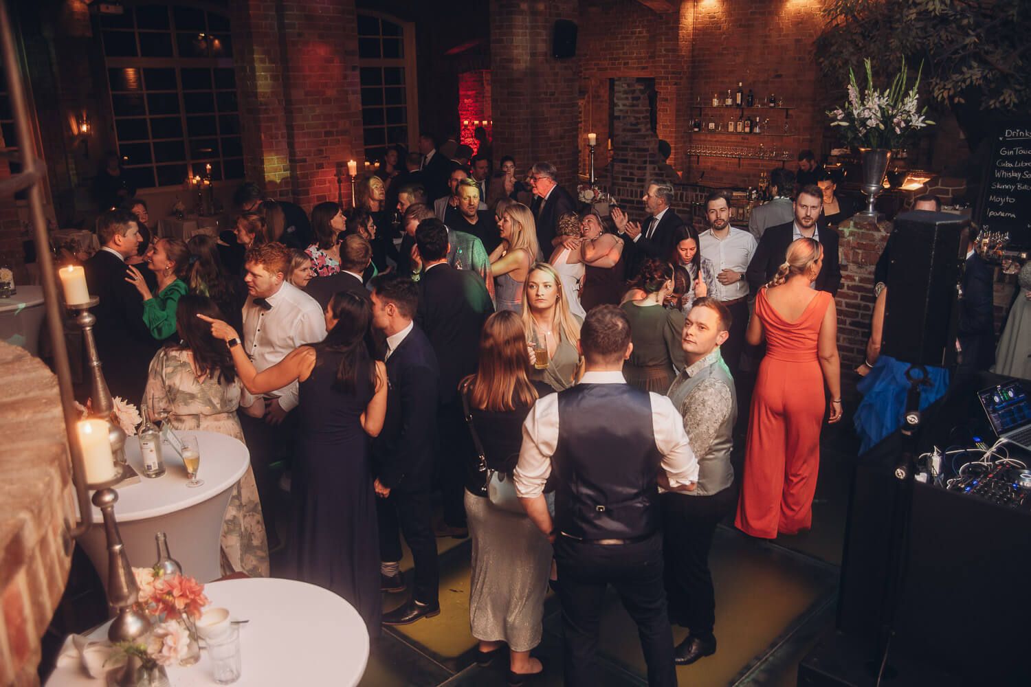Viele Gäste feiern auf der Tanzfläche in einer atmosphärischen Hochzeitslocation, dokumentiert von einem Hochzeitsfotografen aus Hannover