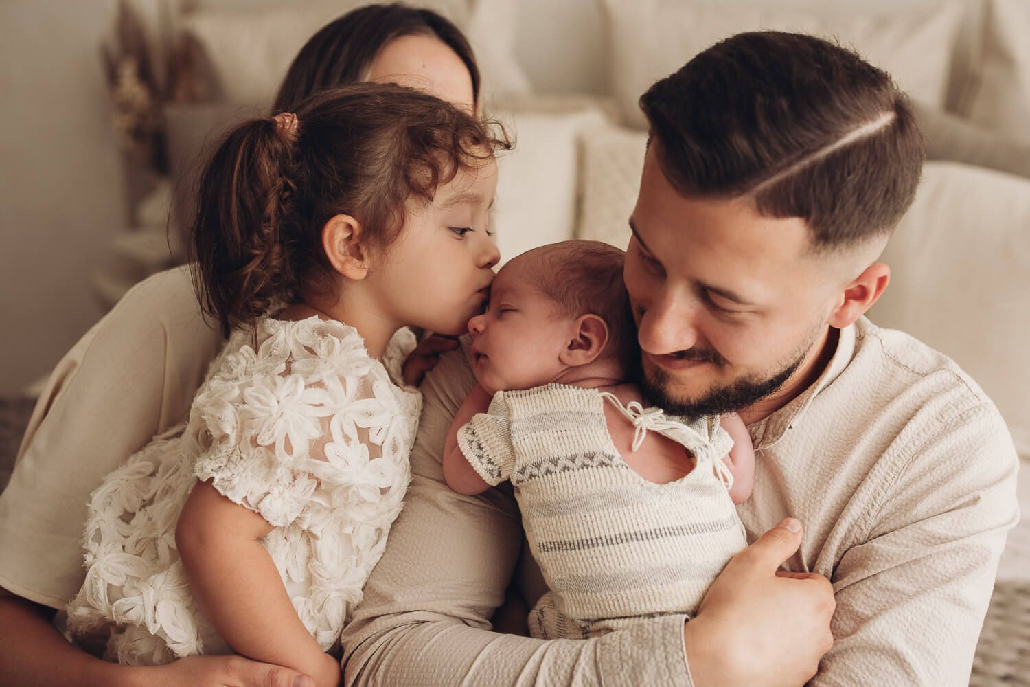 Kleines Mädchen küsst ihr neugeborenes Geschwisterchen beim Familien Fotoshooting in Wolfsburg