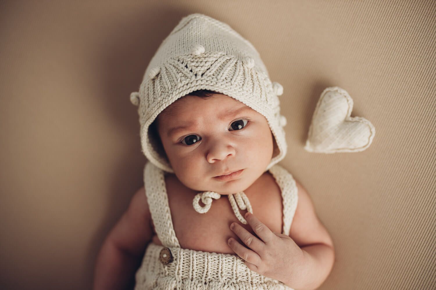 Süßes Babyfoto in Garbsen – Neugeborenes mit gestrickter Mütze und kleinem Herz beim Newborn Shooting