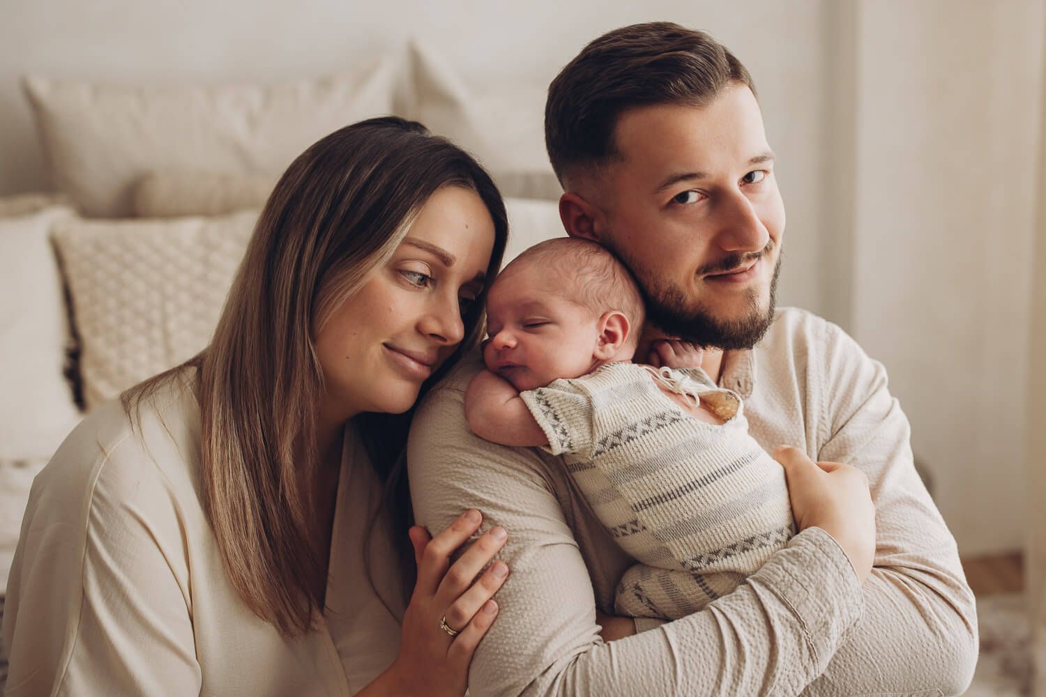 Glückliche Eltern mit ihrem Neugeborenen bei einem warmen und natürlichen Familien Fotoshooting in Gehrden
