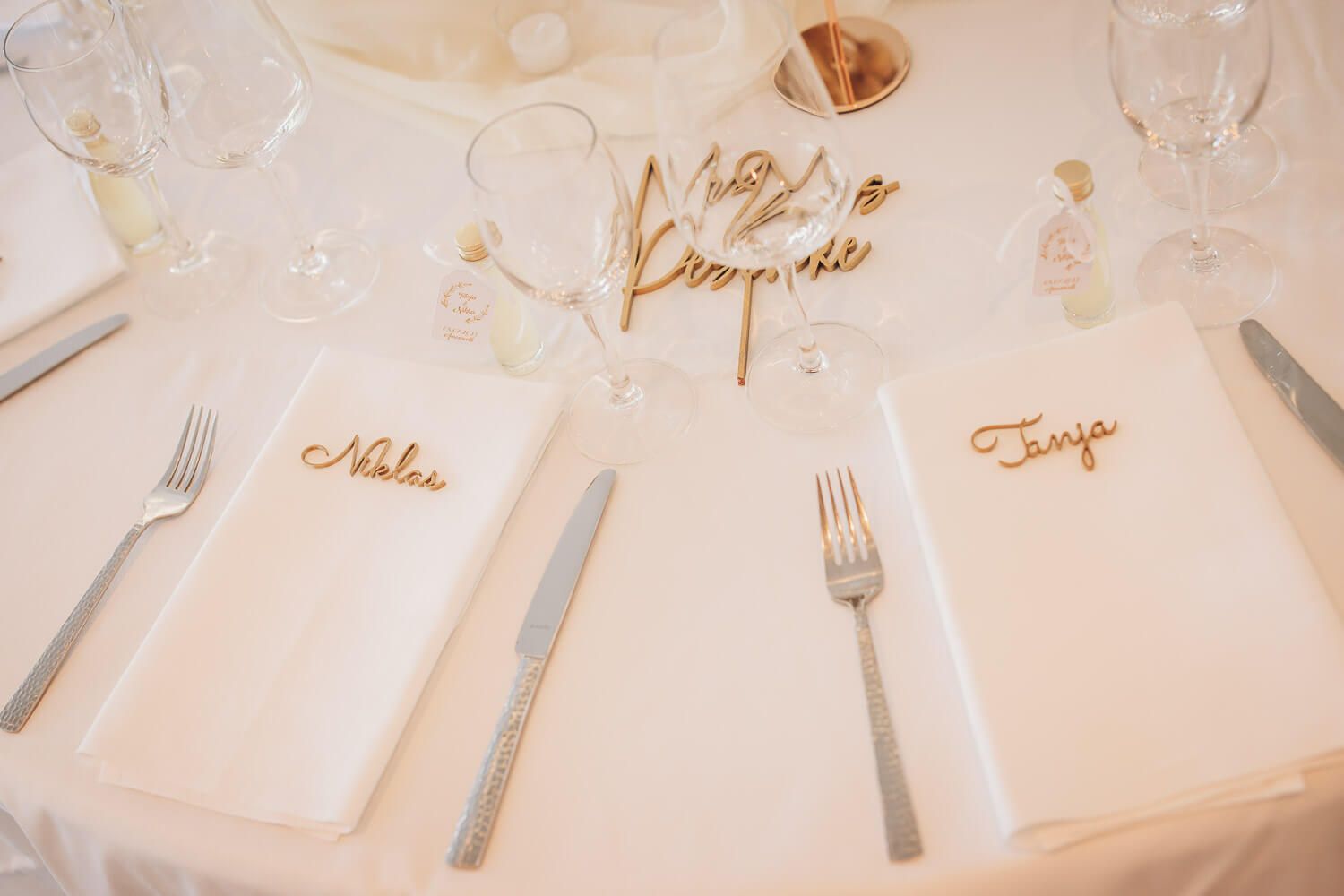 Liebevoll gestaltete Platzkarten mit den Namen des Brautpaares auf dem Hochzeitstisch, detailverliebt fotografiert bei einer freien Trauung