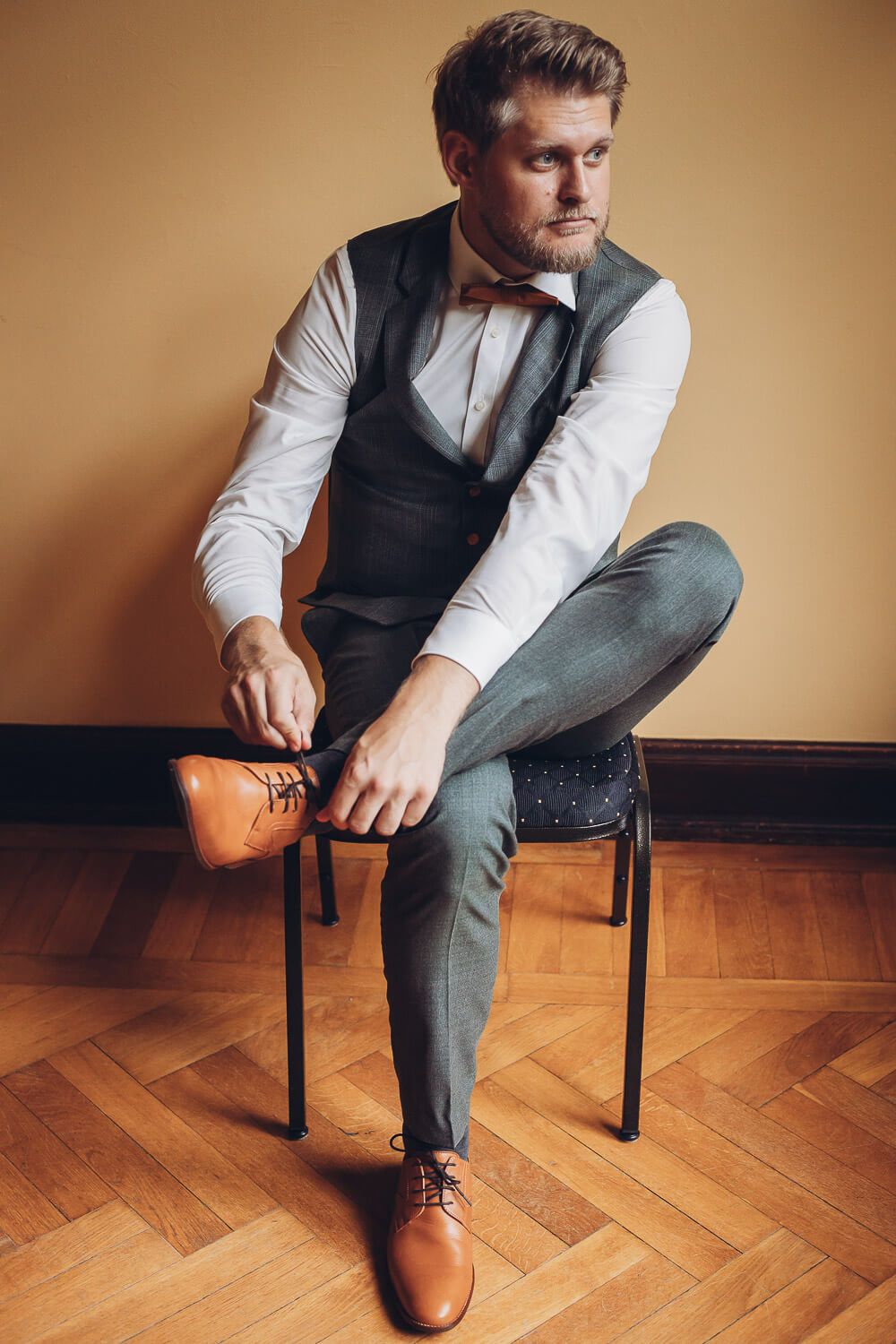 Bräutigam sitzt beim Getting Ready und schnürt seine Schuhe vor der Hochzeit, fotografiert von einer Fotografin in Braunschweig