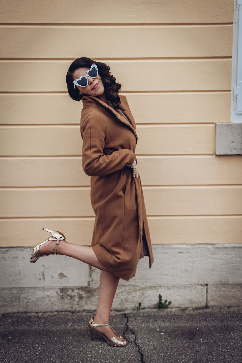 Kreatives Portrait einer Frau im eleganten Vintage-Look mit Herzsonnenbrille, aufgenommen von einer Hochzeitsfotografin in Barsinghausen