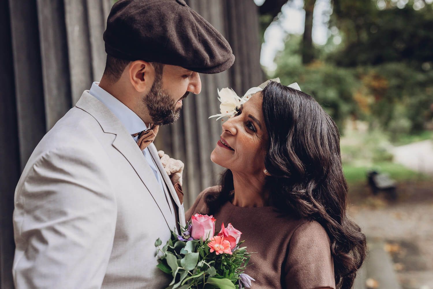 Emotionales Portrait eines Brautpaares mit liebevollem Blickkontakt und farbigem Brautstrauß, fotografiert von einem Fotografen in Hameln