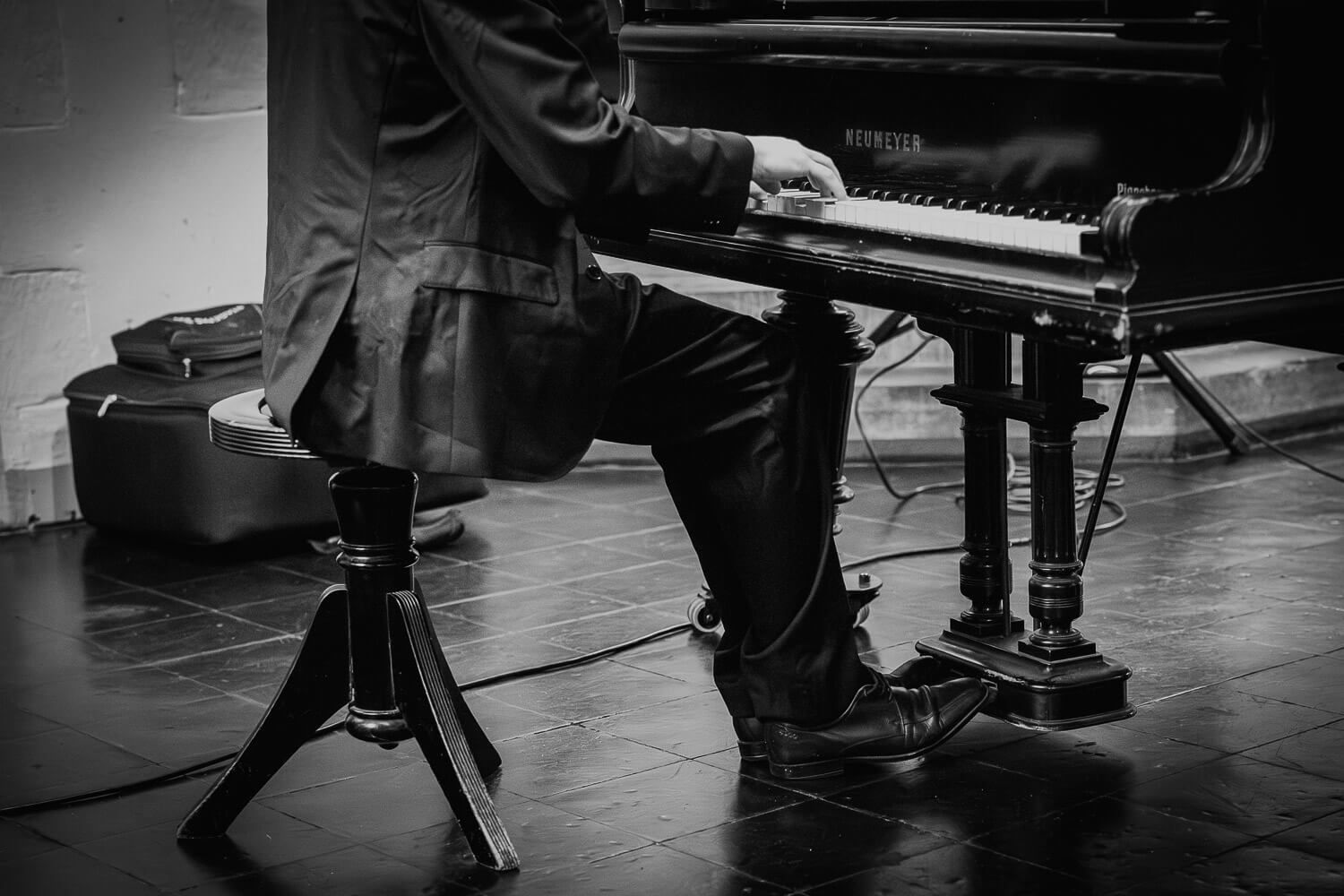Schwarzweißaufnahme eines Pianisten am Flügel während einer emotionalen Hochzeitsreportage in Hannover
