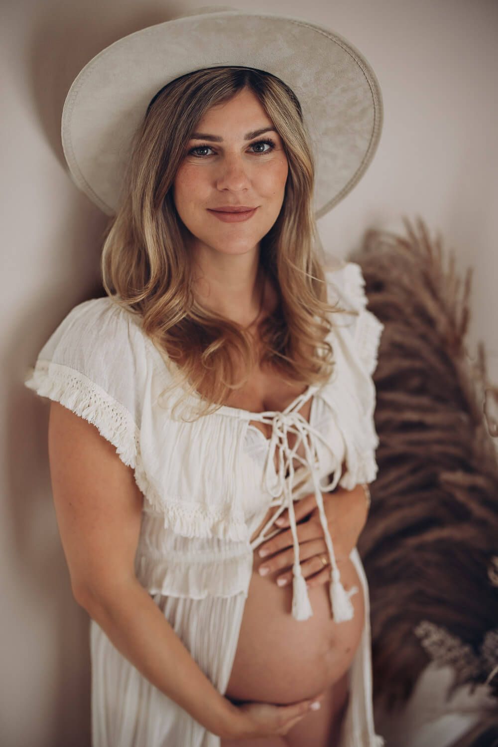 Schwangere Frau im Boho-Stil bei einem natürlichen Babybauch Portrait im Fotostudio