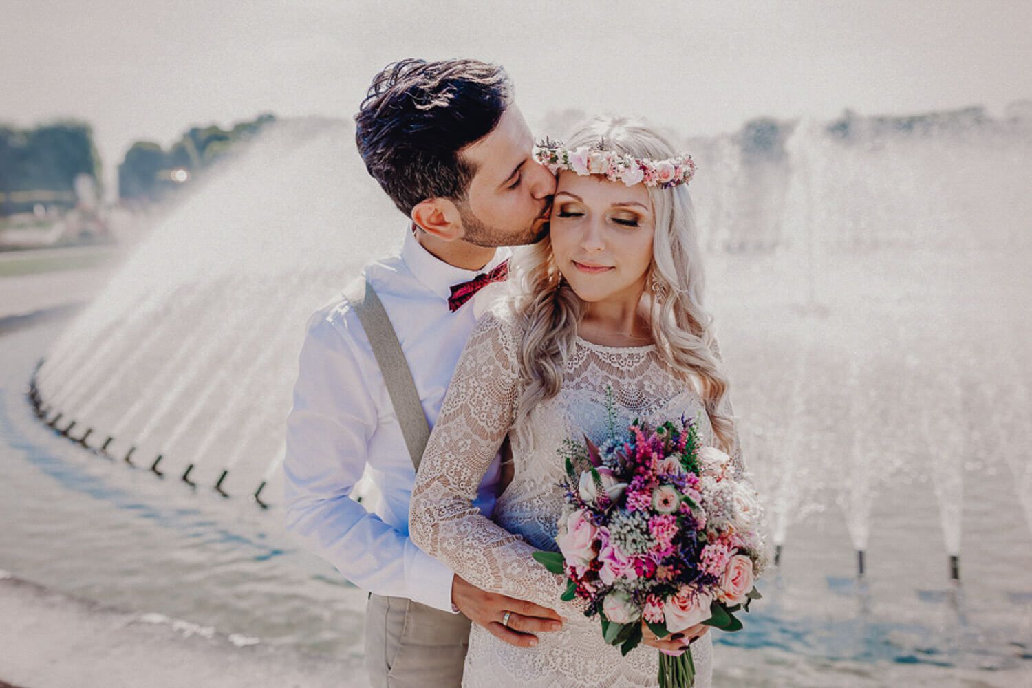 Bräutigam küsst die Braut bei einem romantischen Hochzeitsshooting mit Blumenstrauß in Hannover