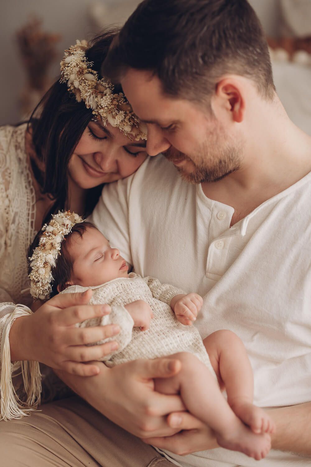 Eltern halten ihr neugeborenes Baby liebevoll im Arm bei einem emotionalen Familien Fotoshooting
