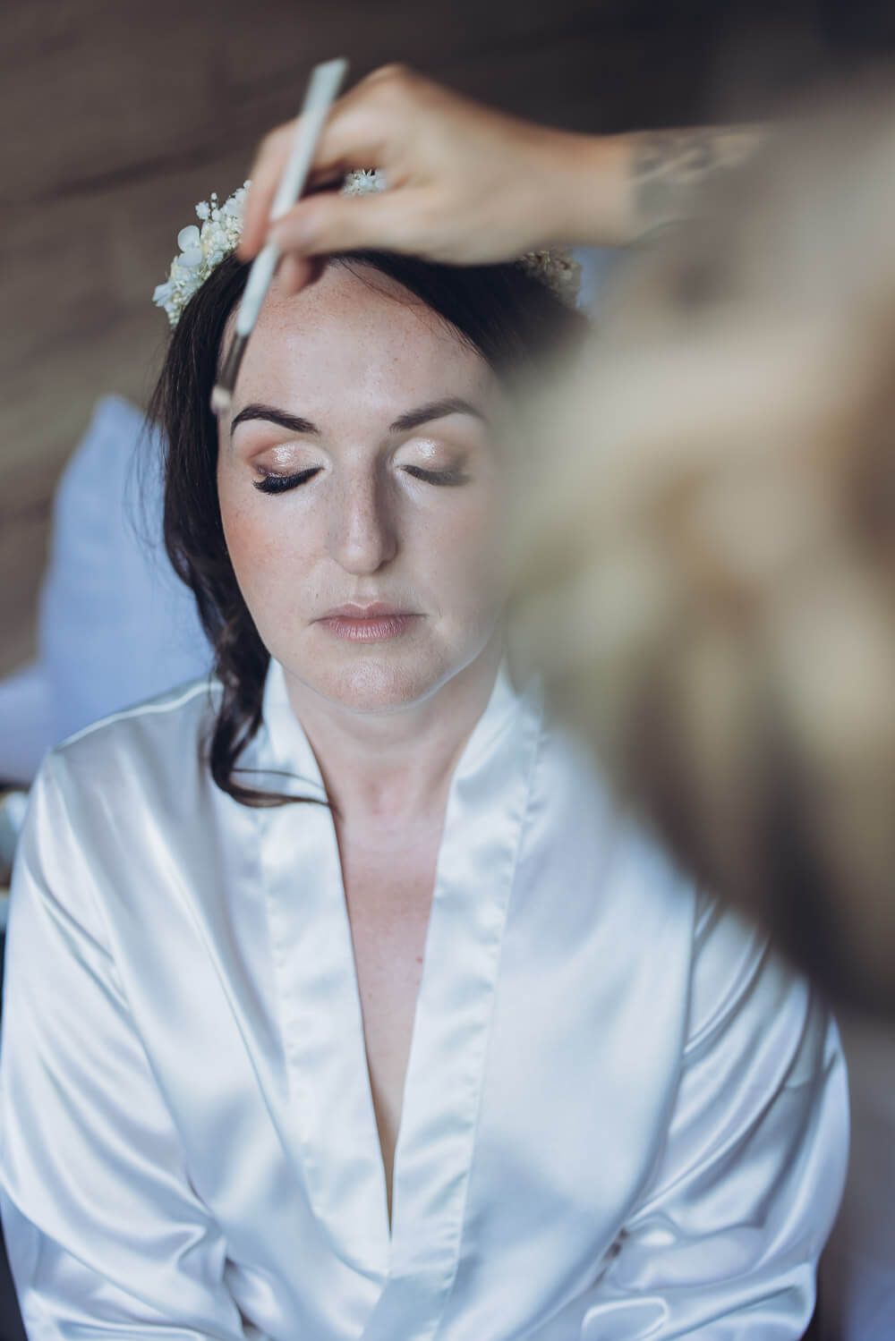 Die Braut sitzt mit geschlossenen Augen entspannt beim Styling, während letzte Vorbereitungen für die freie Trauung in Hildesheim getroffen