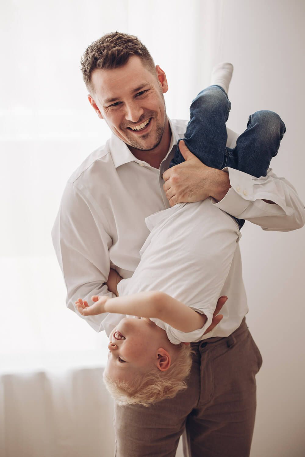 Spielerisches Vater Kind Foto in Langenhagen – Vater hält sein Kind kopfüber und beide lachen ausgelassen beim Shooting