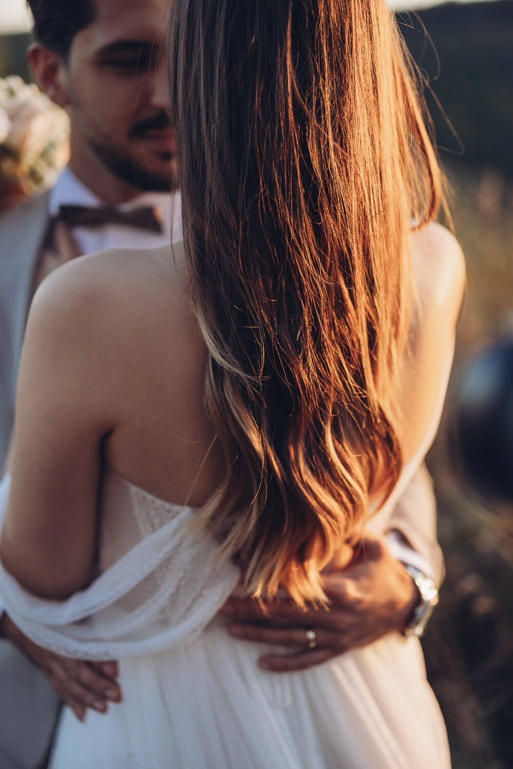 Detailaufnahme der Braut mit leuchtendem Haar und unscharfem Bräutigam im Hintergrund bei einem Hochzeitsshooting in Braunschweig