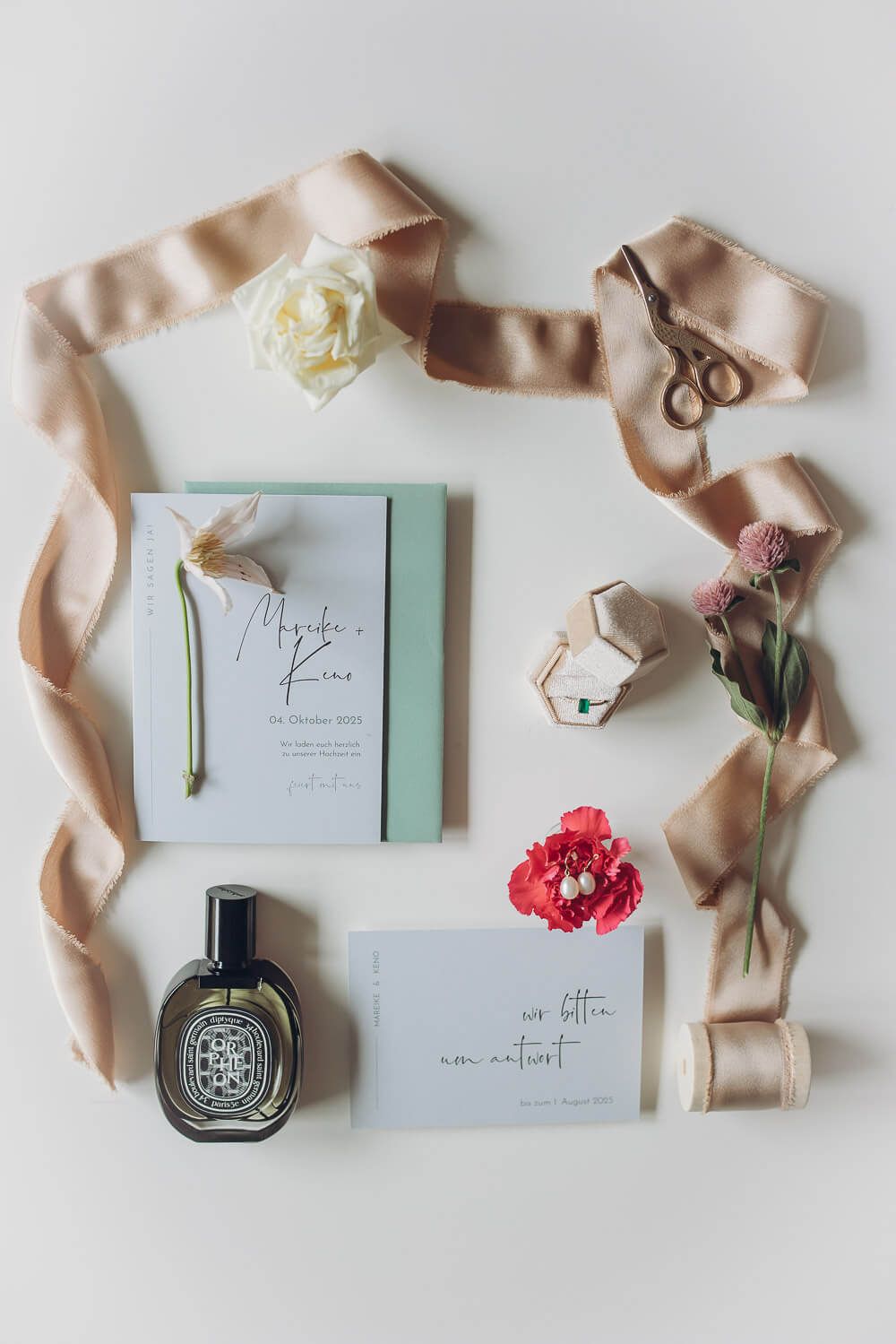 Flatlay mit Hochzeitseinladung, Parfum und Accessoires fotografiert bei einem Hochzeitsfotoshooting in Hannover von einer Hochzeit
