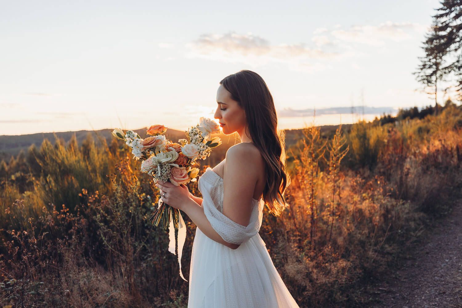Elegantes Brautportrait mit Blumenstrauß im warmen Abendlicht bei einem stilvollen Hochzeitsshooting in Hameln und Hannover