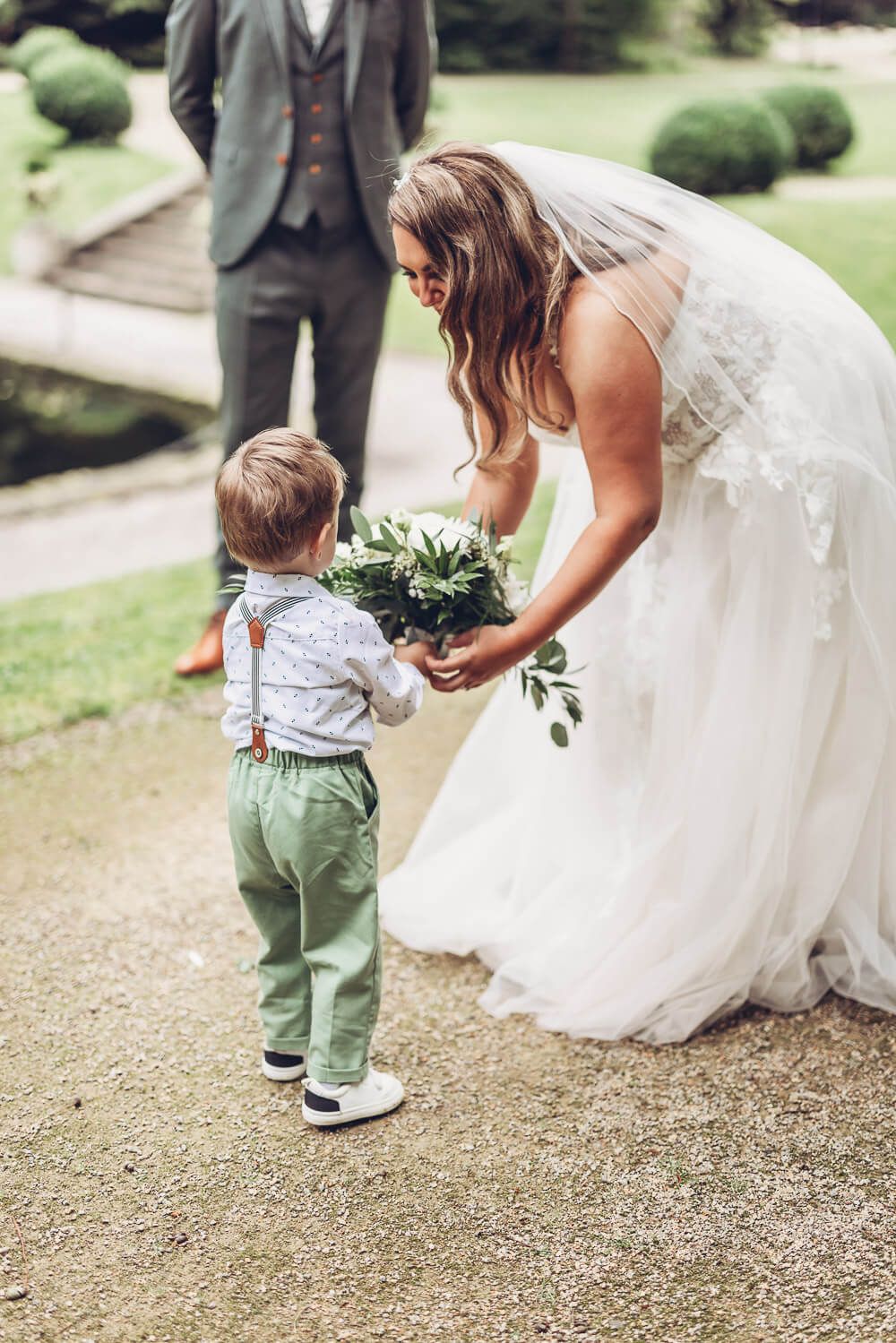 Herzlicher Moment, in dem die Braut einem Kind den Brautstrauß zeigt, fotografiert von einer Hochzeitsfotografin in Celle