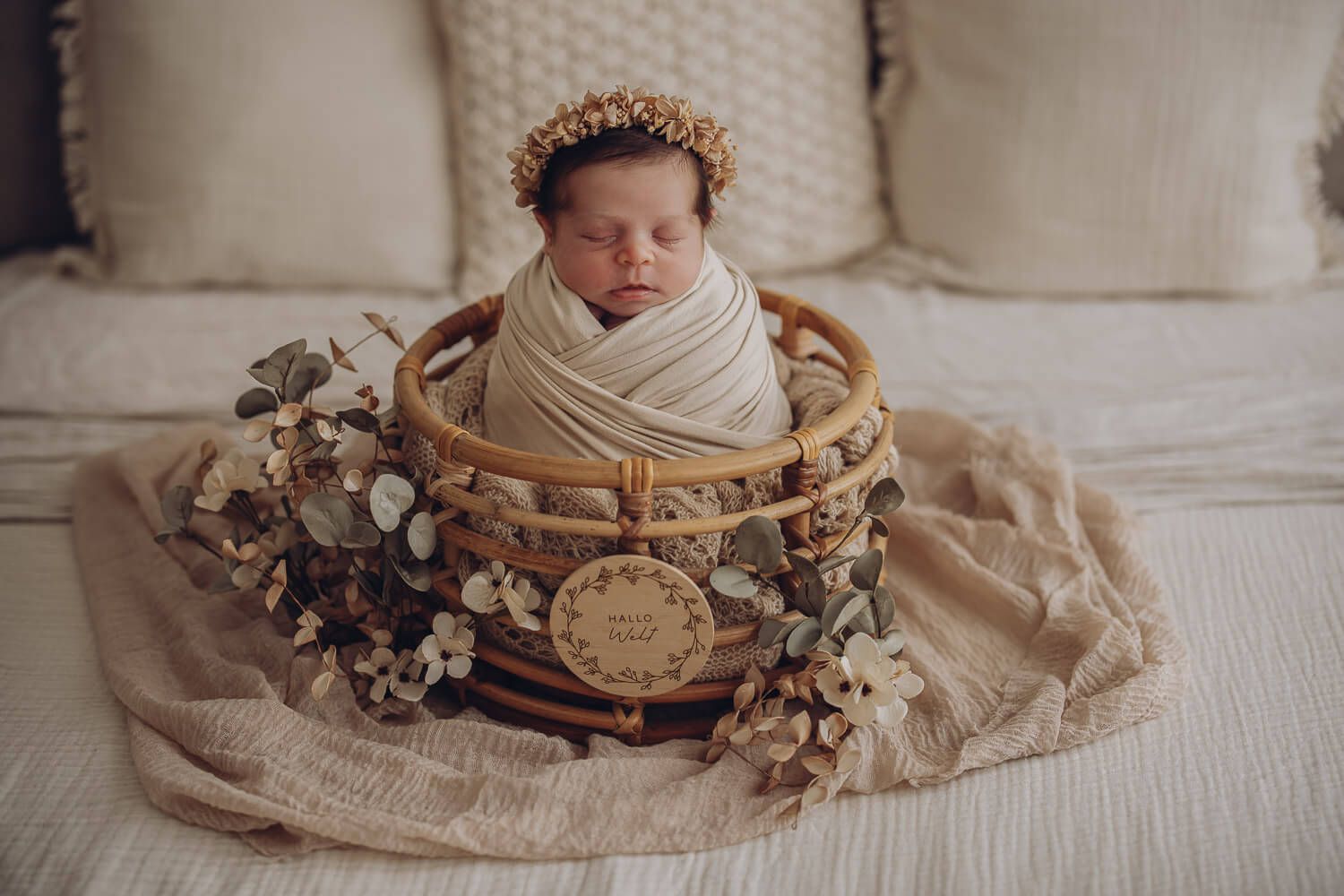Schlafendes Neugeborenes im Körbchen mit Blumen bei einem liebevollen Newborn Fotoshooting in Celle