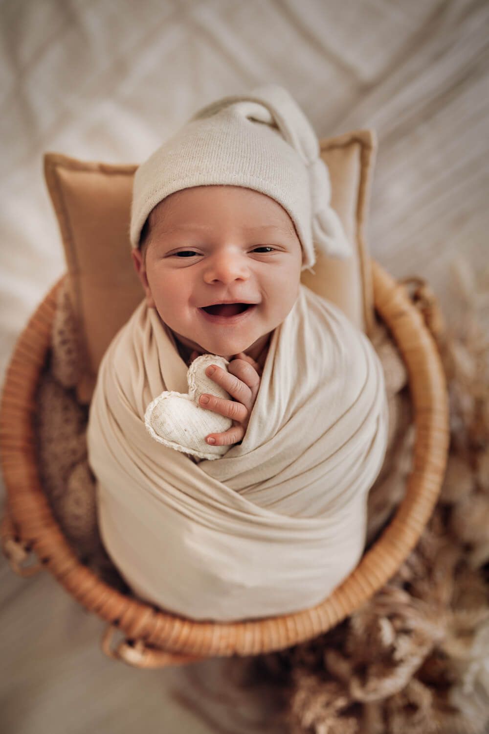 Lächelndes Baby schaut direkt in die Kamera beim liebevollen Newborn Fotoshooting in Langenhagen