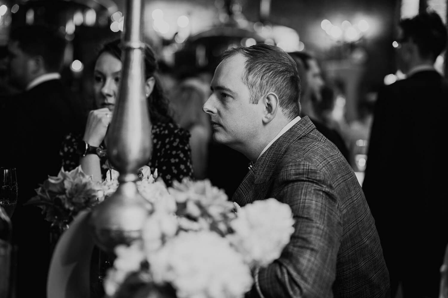 Schwarzweißes Reportagefoto eines Bräutigams während der Hochzeitsfeier, ungestellt und emotional von einem Hochzeitsfotografen aus Hannover