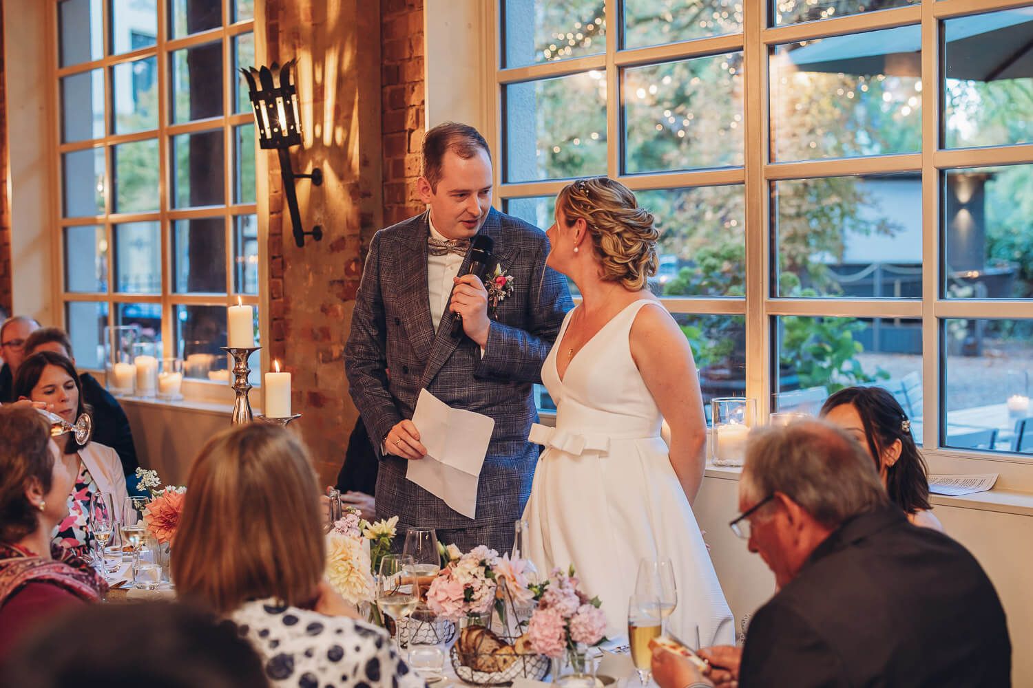 Bräutigam hält bei der Hochzeitsfeier eine Rede neben der Braut, emotional festgehalten von einem Hochzeitsfotografen aus Hannovover