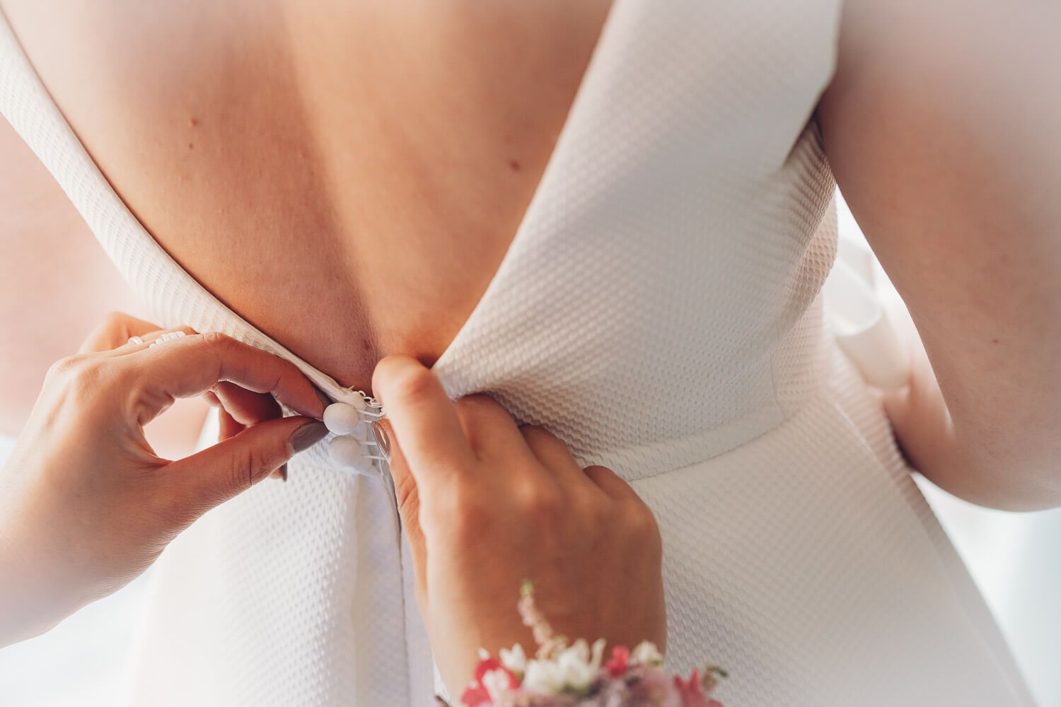 Detailaufnahme vom Schließen des Brautkleids beim Getting Ready einer Hochzeit in Hannover