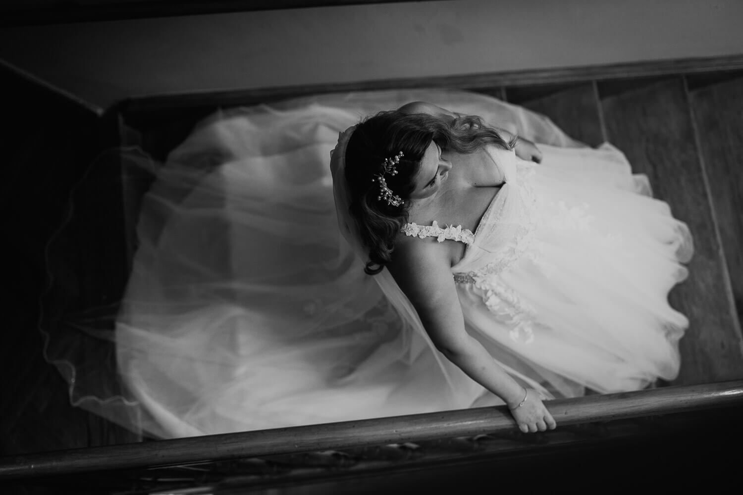 Künstlerisches Schwarz-Weiß-Porträt einer Braut von oben im Treppenhaus - Hochzeitsfotografin Hannover