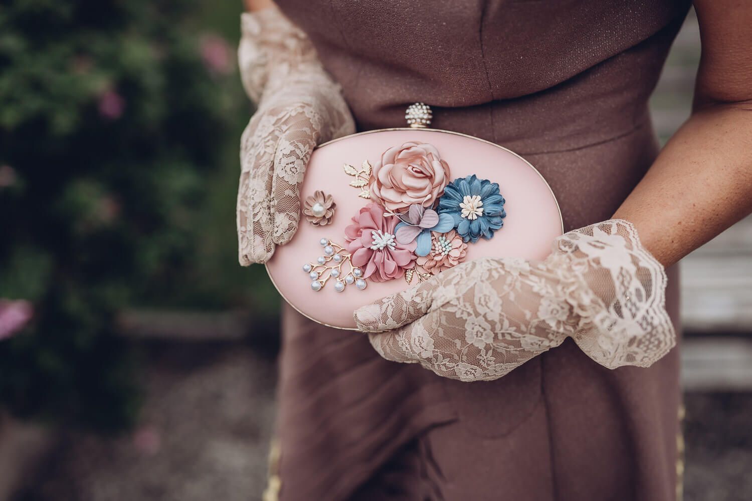 Detailaufnahme einer dekorativen Vintage-Clutch mit floralen Elementen und Spitzenhandschuhen, fotografiert von einer Fotografin in Gehrden