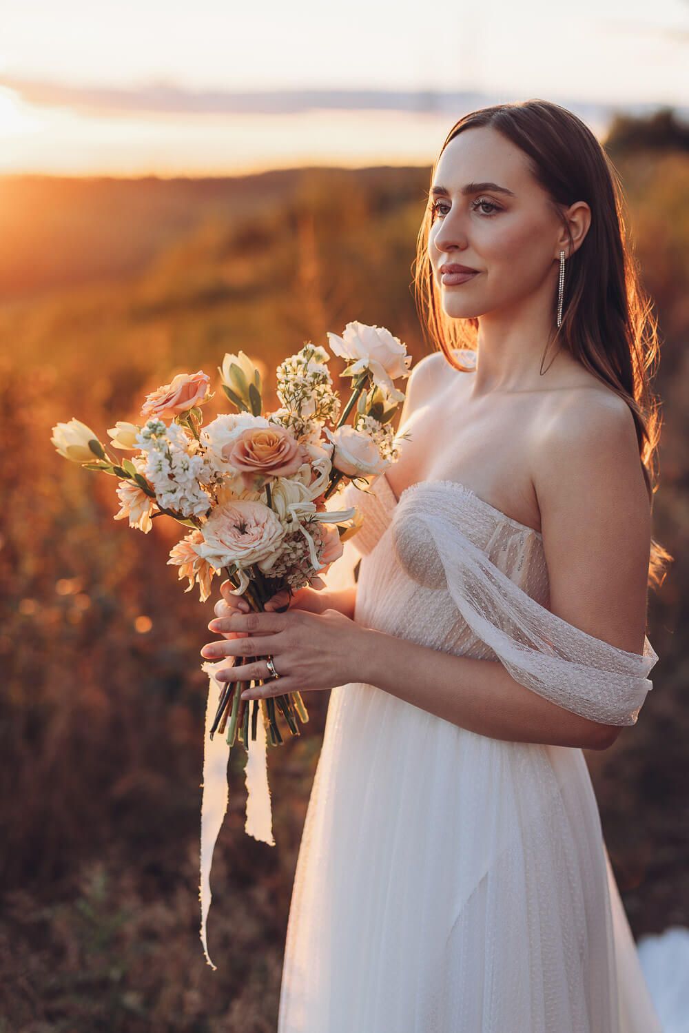 Elegantes Brautportrait mit Blumenstrauß im warmen goldenen Abendlicht bei einem romantischen Hochzeitsshooting in Hildesheim