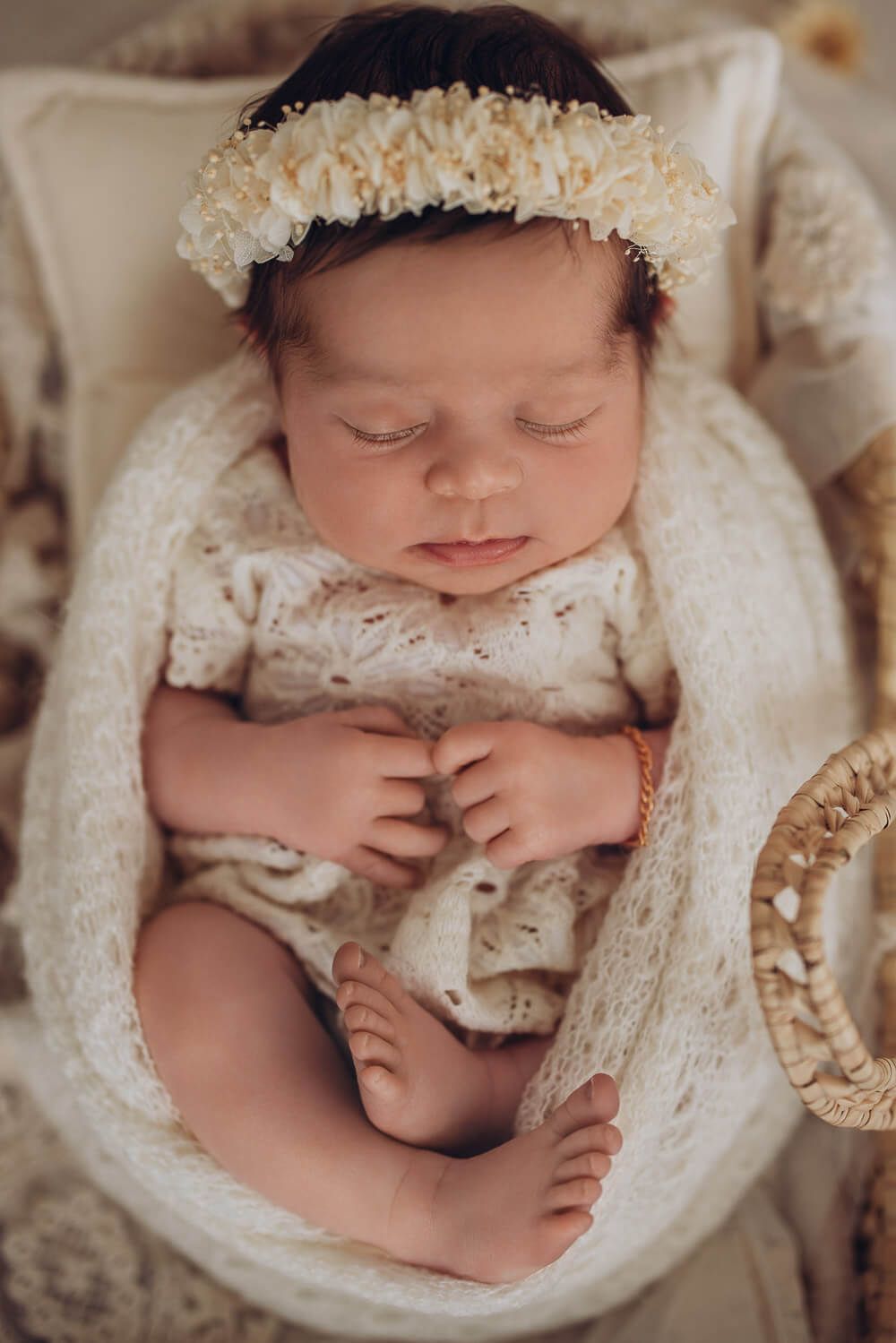 Frontalaufnahme eines schlafenden Neugeborenen mit Blumenkranz bei einem stilvollen Babyshooting in Peine