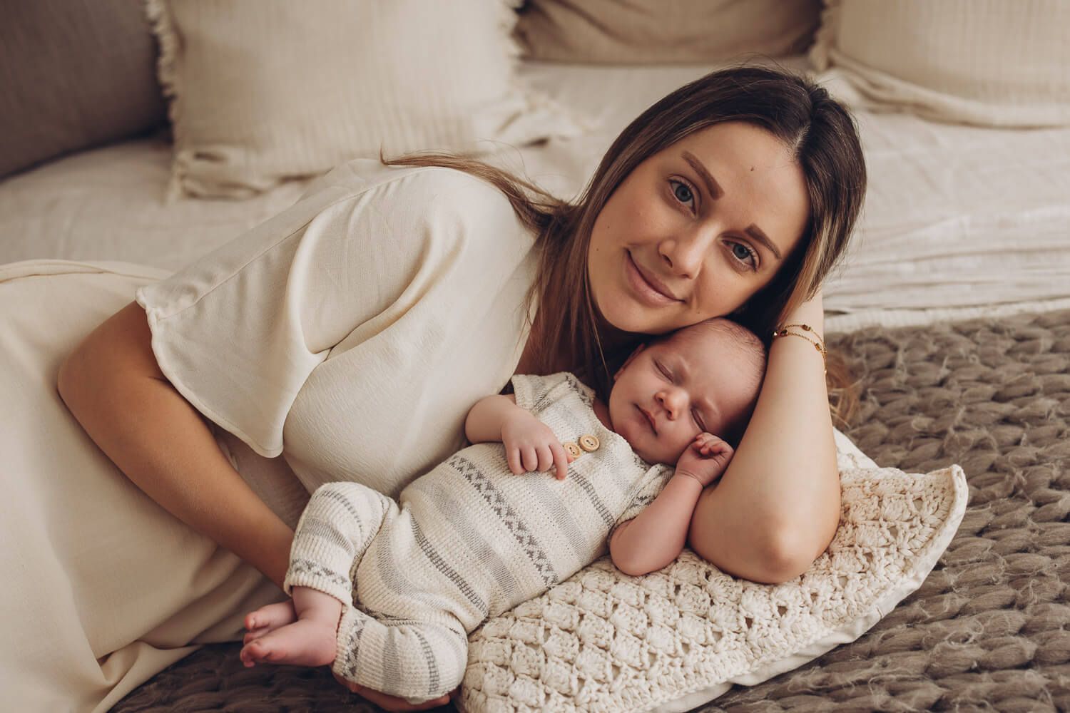 Mutter liegt entspannt neben ihrem schlafenden Baby bei einem natürlichen Fotoshooting in Hameln