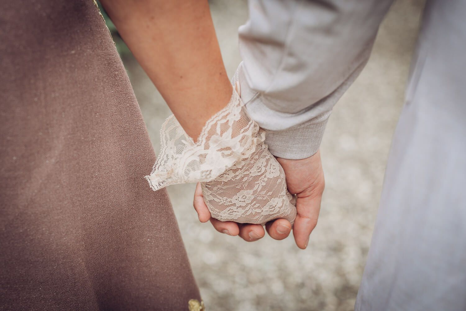 Nahaufnahme der ineinanderliegenden Hände eines Brautpaares mit Spitzenhandschuh, fotografiert von einer Fotografin in Hildesheim