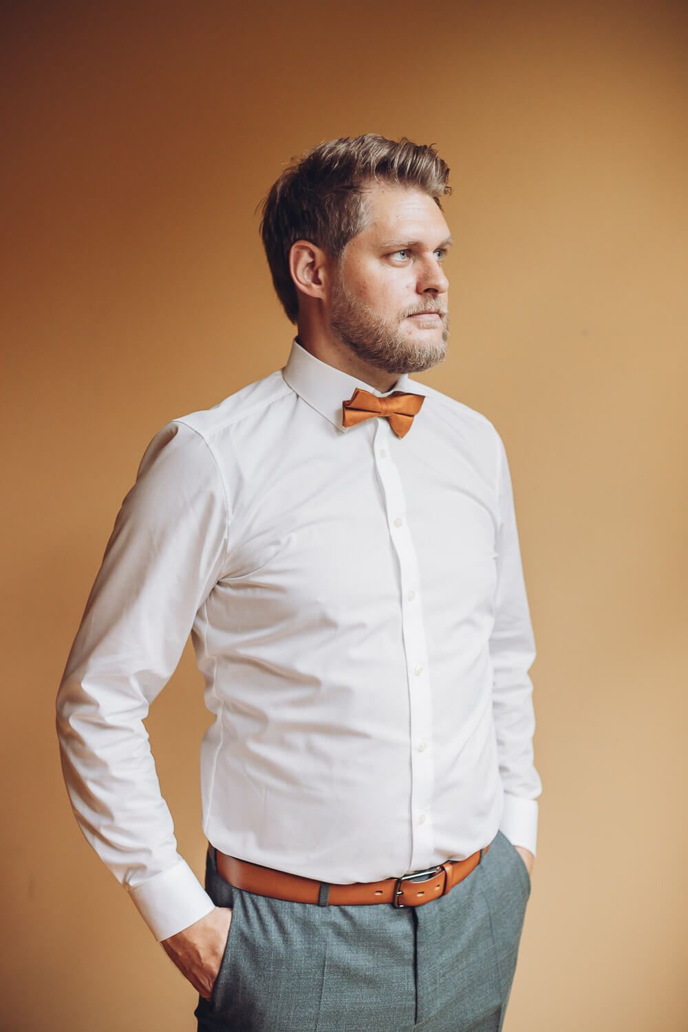 Stilvolles Portrait des Bräutigams mit weißem Hemd und Fliege vor der Trauung, fotografiert von einer Hochzeitsfotografin in Hannover