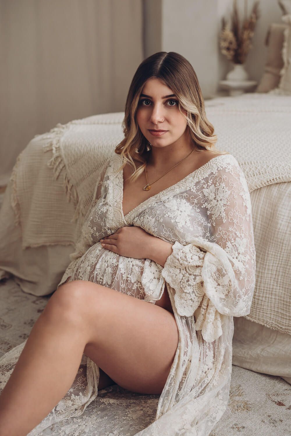 Schwangere Frau sitzt auf dem Teppich und macht ein Fotoshooting in Hannover