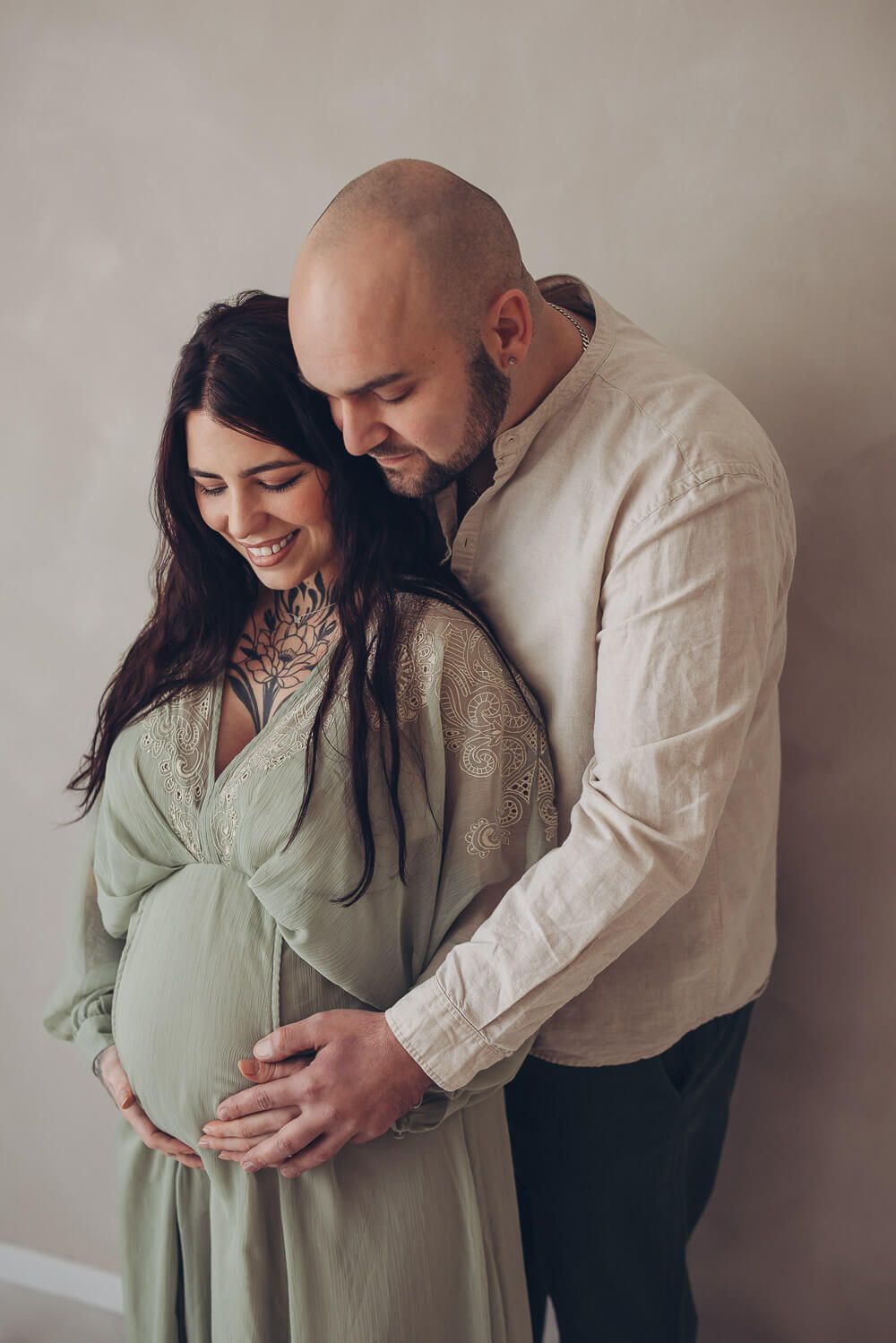 Natürliches Paarportrait beim Babybauch Fotoshooting in Garbsen – werdende Eltern halten gemeinsam den Bauch