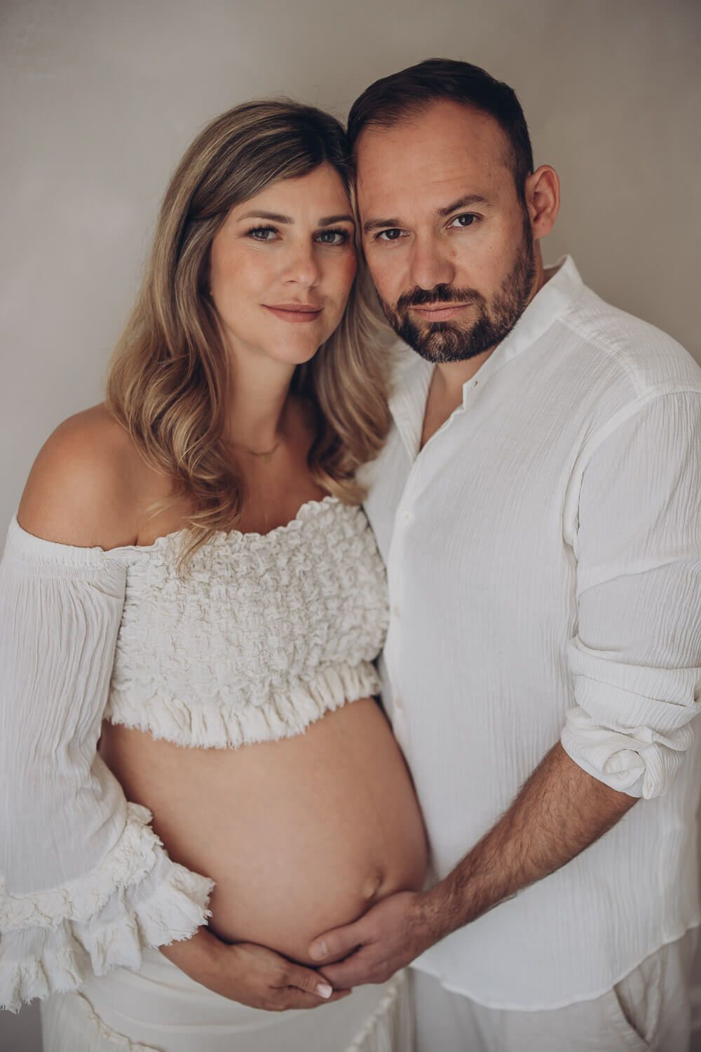 Klassisches Babybauch Fotoshooting in Bückeburg – werdende Eltern stehen nah beieinander und blicken ruhig in die Kamera