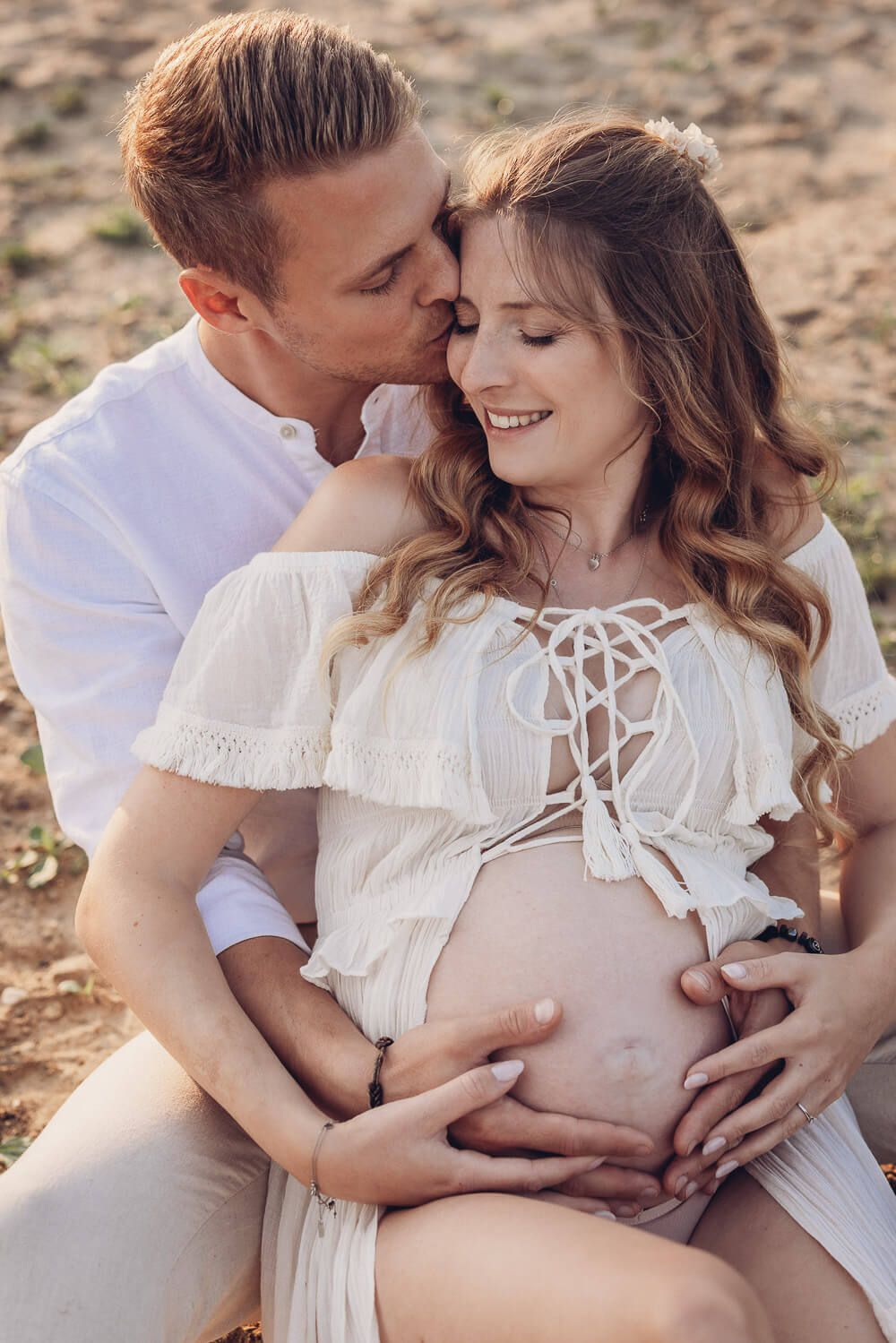 Zärtliches Babybauch Fotoshooting in Braunschweig – Partner küsst liebevoll die schwangere Frau