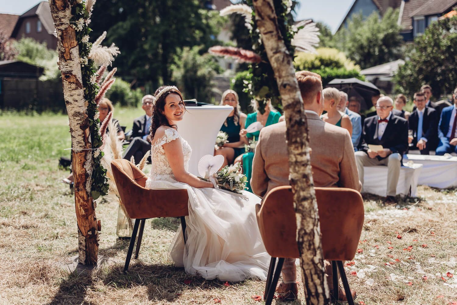 Braut wirft während der freien Trauung in Hannover einen glücklichen Blick zu ihren Gästen - Hochzeitsfotograf