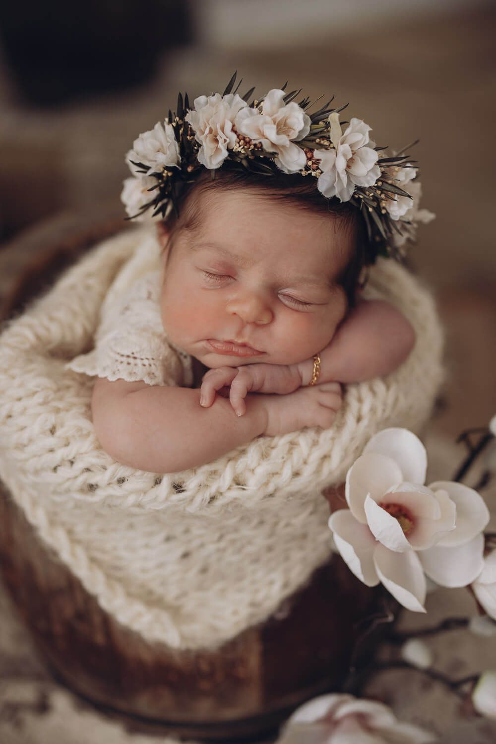 Nahaufnahme eines schlafenden Neugeborenen mit Blumenkranz bei einem Babyshooting in Großburgwedel