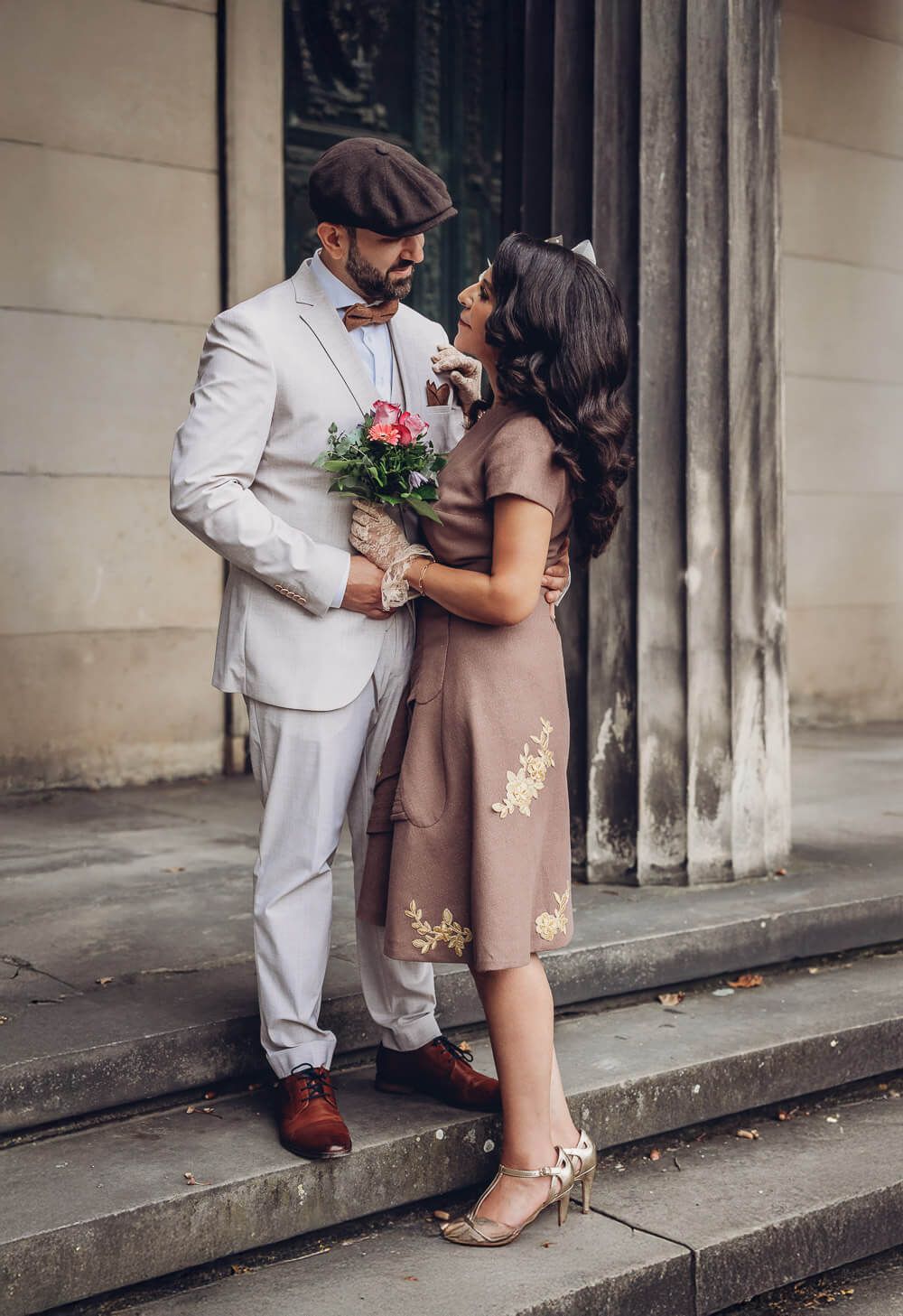 Stilvolles Brautpaar im Vintage-Outfit steht auf Treppe vor klassischer Architektur - Hochzeitsfotograf in Hannover, Hildesheim, Wolfsburg