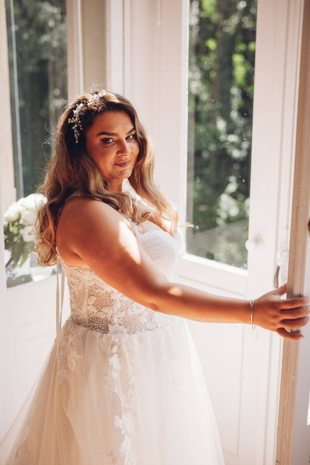Natürliches Brautportrait am Fenster mit sanftem Licht während der Hochzeitsreportage, aufgenommen von einem Fotografen in Hameln