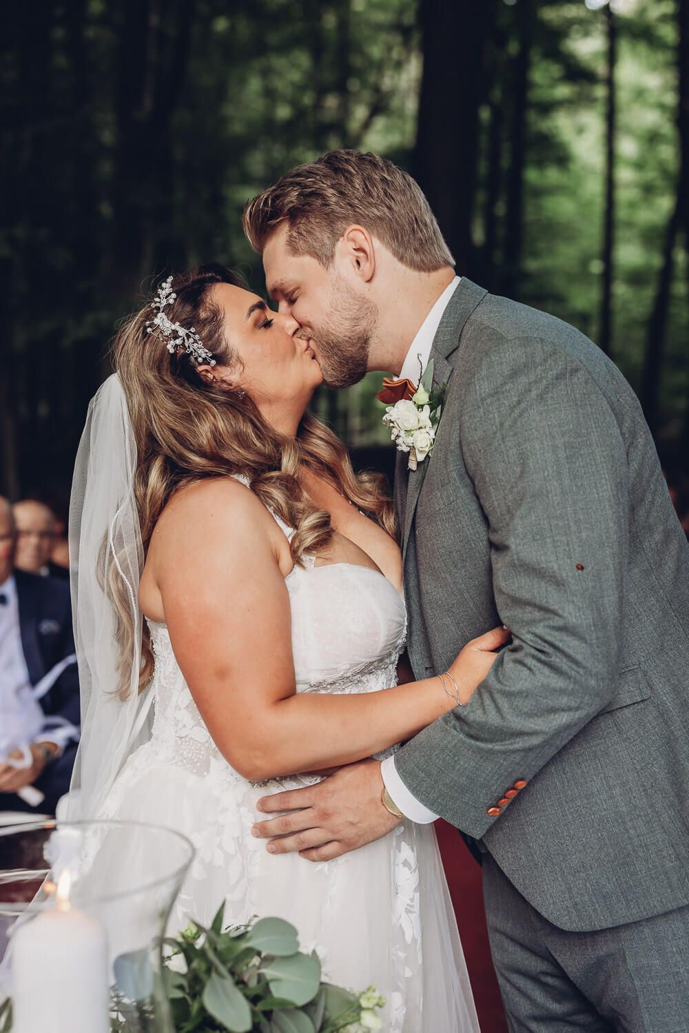 Frisch verheiratetes Brautpaar küsst sich während der Trauung im Grünen, aufgenommen von einer Fotografin in Minden