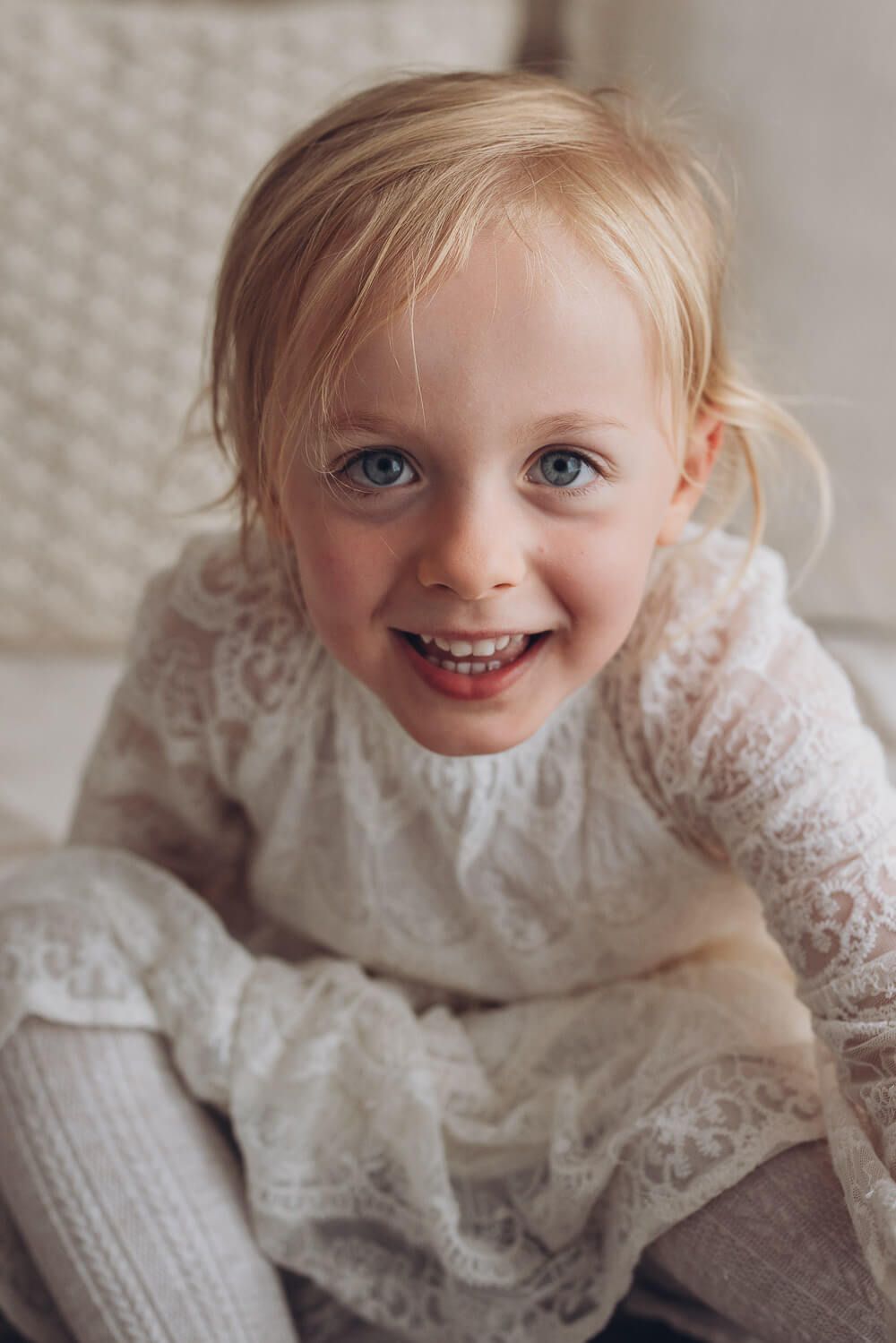 Nahaufnahme eines lachenden Mädchens mit großen Augen im natürlichen Licht – Kinderportrait Fotografie in Hannover und Peine